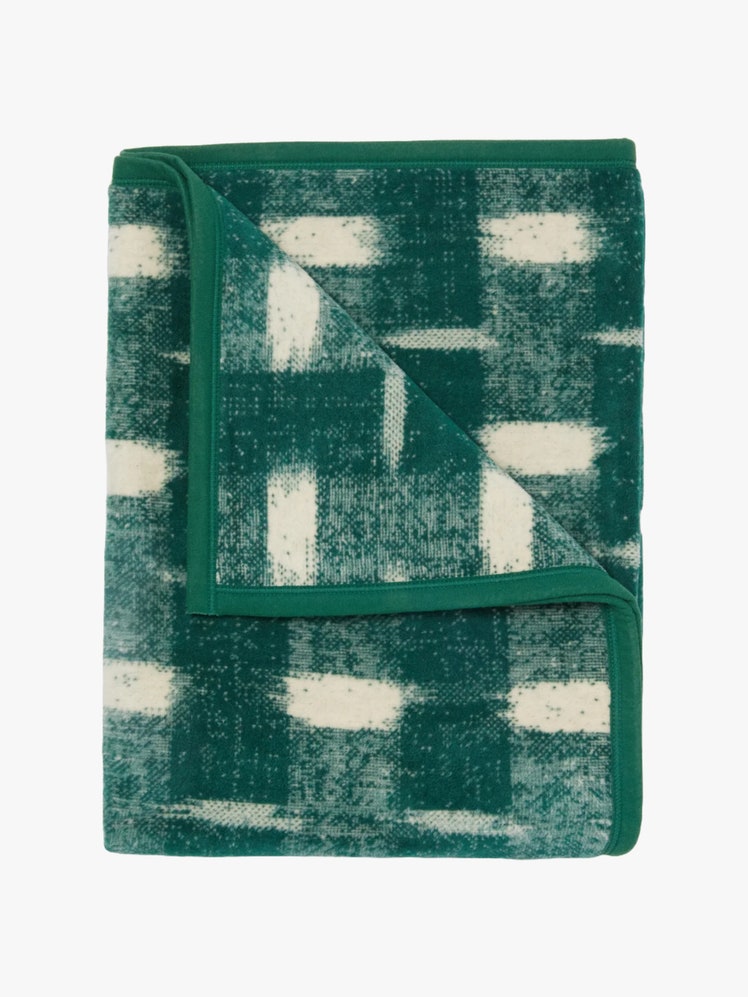 Folded up green blanket in Ikat print.