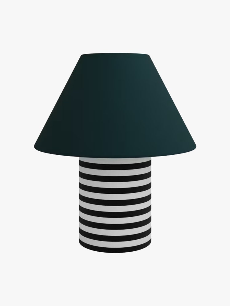 Table lamp with cylindrical white and black striped base and green angled shade.