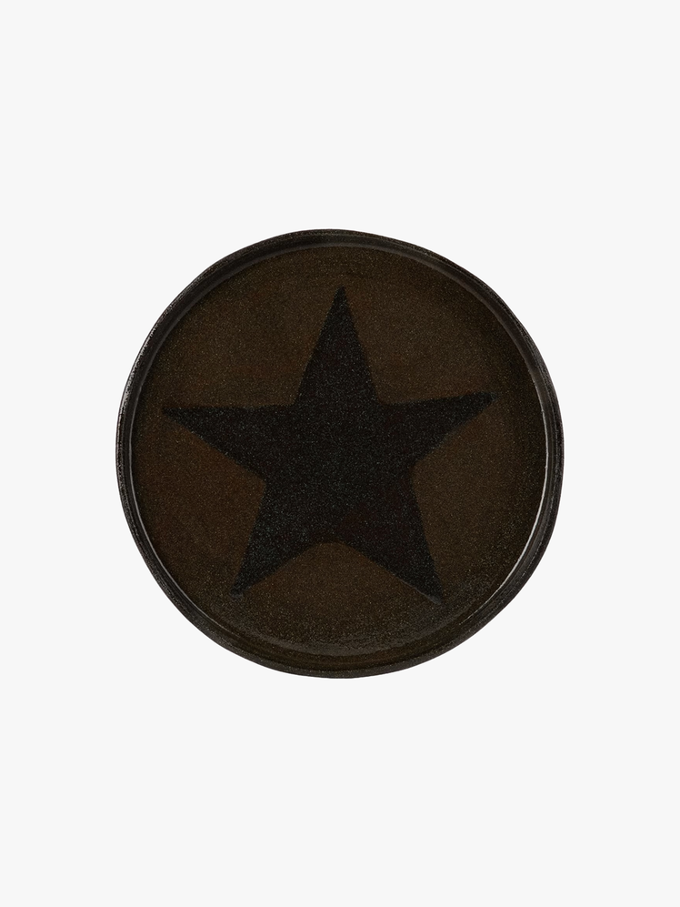 Dark brown plate with large black star at center.