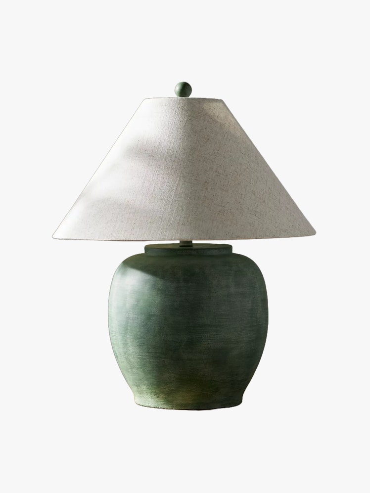 Table lamp with rounded green cement base and a white tapered shade.