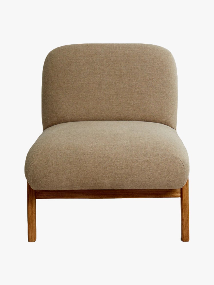 Armchair with an ash wood frame and rounded cushions upholstered in linen fabric.