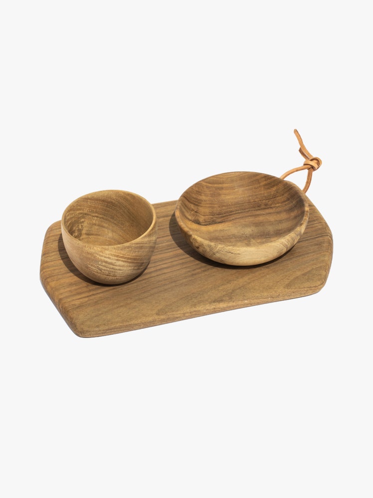 Rectangular cutting board and two wooden bowls all made from walnut wood.