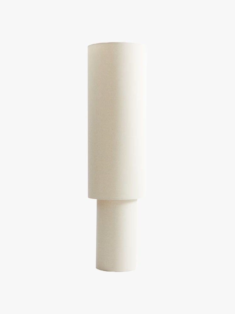 Cylindrical floor lamp in a white fabric.