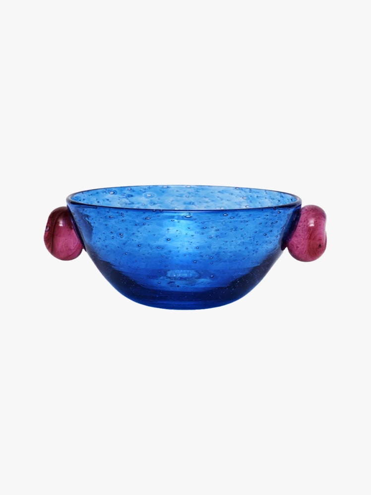 Blue handblown glass bowl with two purple circular handles on each side.