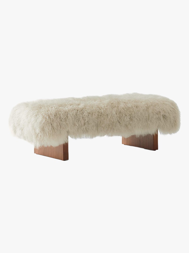 Rectangular bench with a seat upholstered in sheepskin.