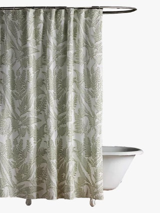 Botanical print shower curtain hanging over a bathtub.