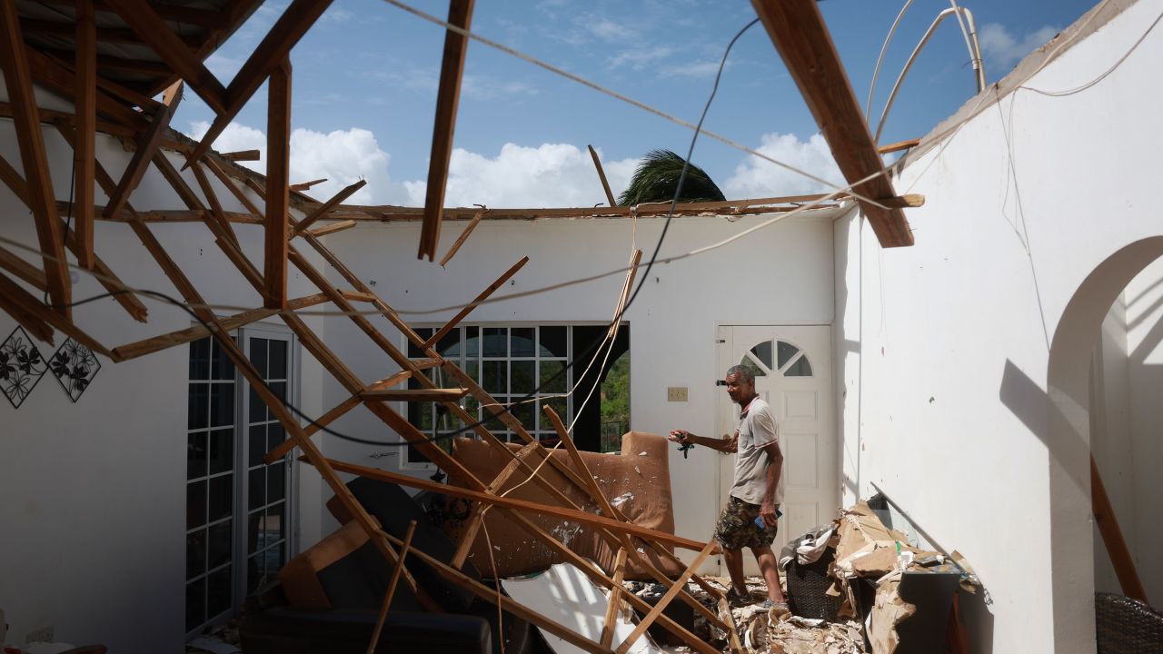 A man walks through his living room after the roof of the home was blown off by the winds from Hurricane Beryl in Saint Elizabeth Parish, Jamaica, on July 4. 