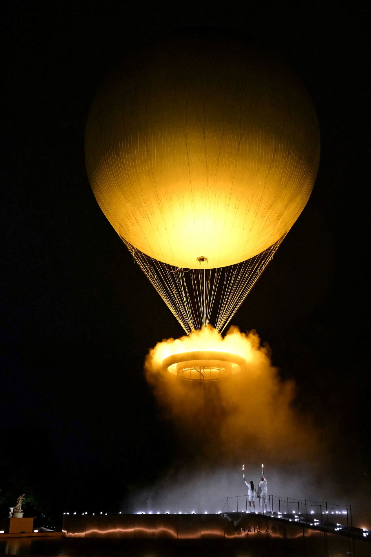 The cauldron, with the Olympic flame lit, lifts off while attached to a balloon at the Jardin des Tuileries. 