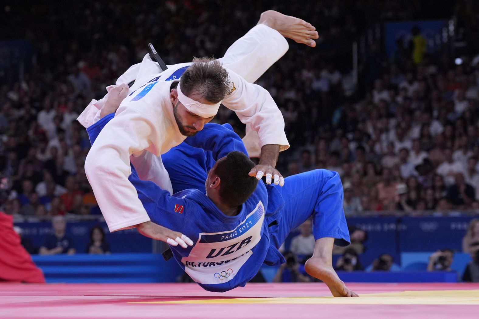 Azerbaijan's Zelym Kotsoiev, top, and Uzbekistan's Muzaffarbek Turoboyev compete in a judo semifinal on August 1. <a href="https://www.cnn.com/sport/live-news/paris-olympics-news-2024-08-01-24#h_64b2fa86bf716965285544ea96743ae2">Kotsoiev would go on to win the gold</a>. Toroboyev won the bronze.