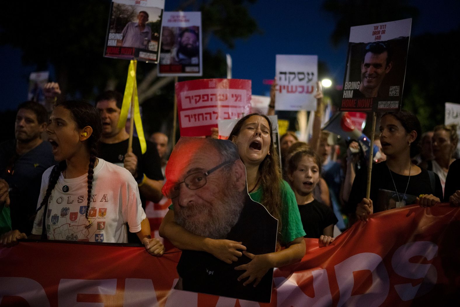 A photo of Alex Dancyg is held by his granddaughter Eliya during a rally in Tel Aviv, Israel, on Tuesday, July 23. Dancyg, a <a href="https://www.cnn.com/middleeast/live-news/israel-hamas-war-gaza-news-10-20-23#h_ebcd16da41aea60d601b679d81d95109">world authority on Holocaust history</a>, was among the hostages taken by terror group Hamas in October. The Israel Defense Forces said this week that Dancyg is no longer believed to be alive.