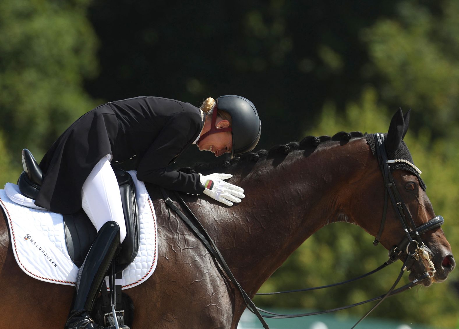 Germany's Jessica von Bredow-Werndl pets her horse TSF Dalera BB after <a href="https://www.cnn.com/sport/live-news/paris-olympics-news-2024-08-04#h_e279e4f7faf98573692a09d50fdebccb">winning the individual dressage title</a> on August 4.