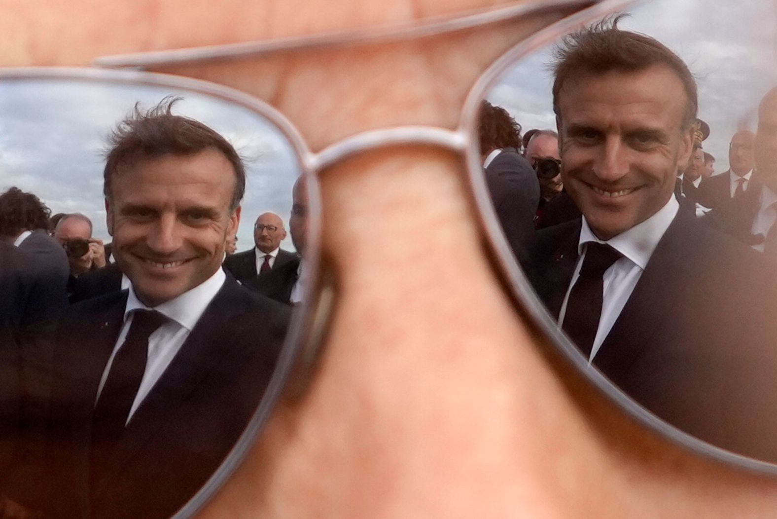 French President Emmanuel Macron is reflected in a person’s glasses on Tuesday, June 18, after a ceremony on the island of Île de Sein paid homage to residents who left the island to join World War II in 1940.