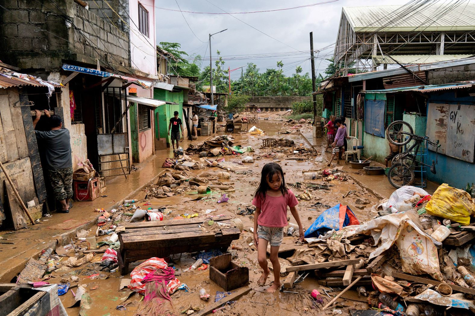 A girl walks past debris and mud in Marikina, Philippines, following flooding caused by <a href="https://www.cnn.com/2024/07/25/asia/philippines-flooding-manila-climate-typhoon-gaemi-intl-hnk/index.html">Typhoon Gaemi</a> on Thursday, July 25.