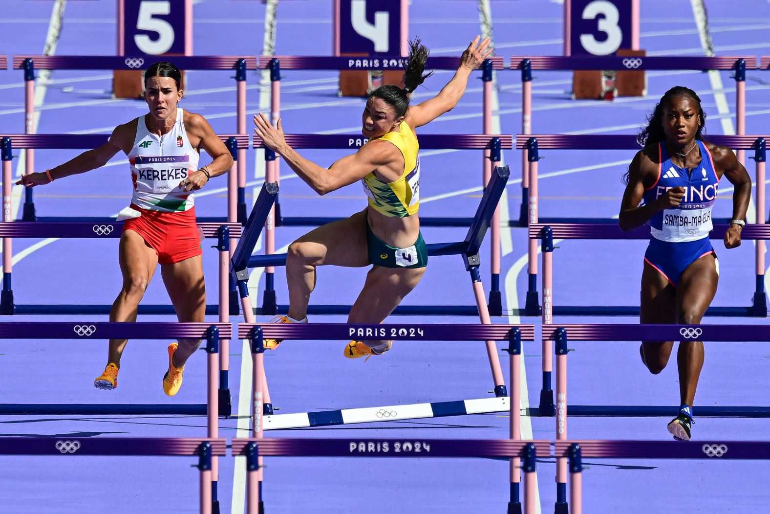 Australia's Michelle Jenneke falls as Hungary's Gréta Kerekes, left, and France's Cyréna Samba-Mayela compete in the 100-meter hurdles on August 7.