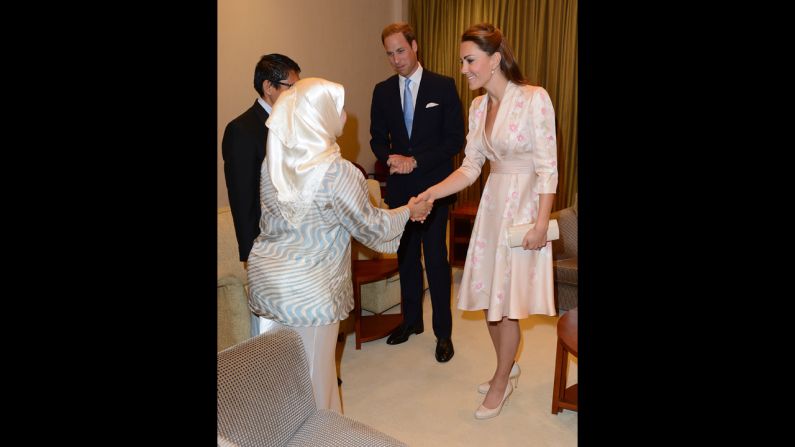 The royal couple is greeted at the airport on Tuesday.