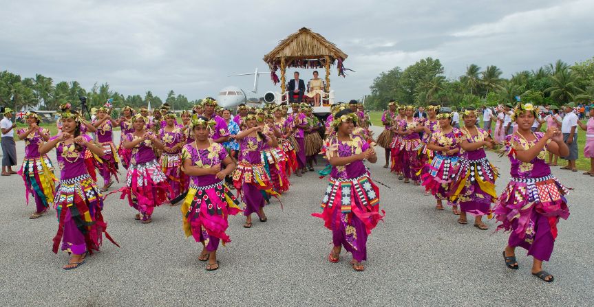 The royal couple are carried from their plane to a welcoming ceremony in Tuvalu on Tuesday. 