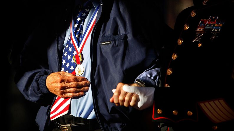 Jim Brown, right, helps fellow veteran Howard Mills to the stage during a Veterans Day ceremony in Collierville, Tennessee, on Sunday. Brown, 83, served in Vietnam and Korea. Mills, 91, served on D-Day during World War II.