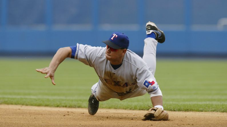 Rodriguez dives for a ground ball and throws to first during a game against the New York Yankees at Yankee Stadium on August 26, 2002.