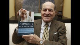 FILE - In this Feb. 5, 2014, file photo, Dr. Henry Heimlich holds his memoir prior to being interviewed at his home in Cincinnati. Heimlich, the surgeon who created the life-saving Heimlich maneuver for choking victims has died Saturday, Dec. 17, 2016, at Christ Hospital in Cincinnati. He was 96. (AP Photo/Al Behrman, File)