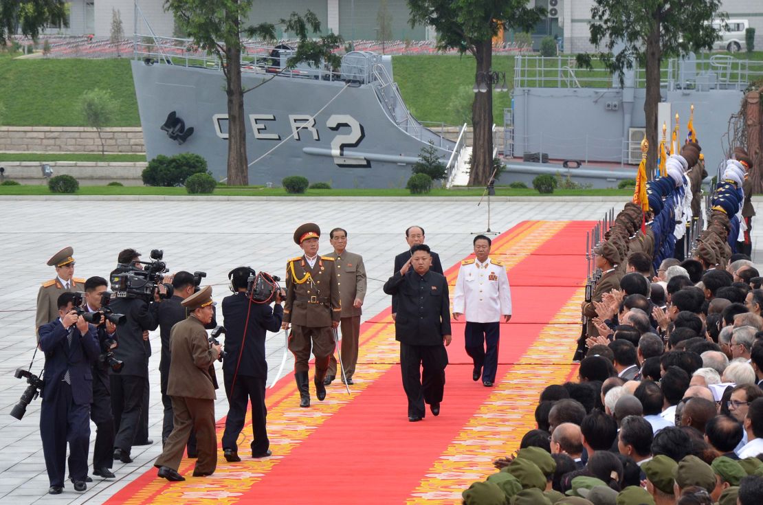 Noth Korean leader Kim Jong Un salutes as he walks in front of the USS Pueblo in Pyongyang on July 27, 2013.