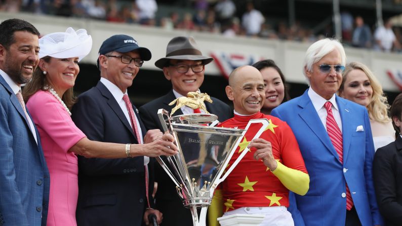 The team behind Justify poses with the new Triple Crown trophy after their horse won the Belmont Stakes and the Triple Crown on Saturday, June 9, in Elmont, New York.