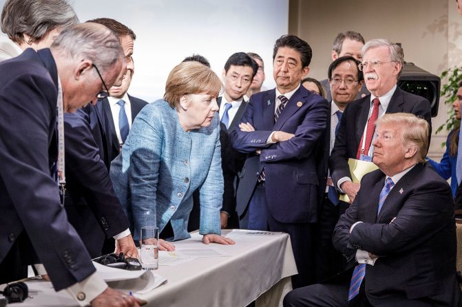 In this photo provided by the German Government Press Office, German Chancellor Angela Merkel talks with a seated Trump as they are surrounded by other leaders at the G7 summit in Charlevoix, Quebec, in June 2018. According to two senior diplomatic sources, <a href="https://www.cnn.com/2018/06/11/politics/g7-photo/index.html" target="_blank">the photo was taken</a> when there was a difficult conversation taking place regarding the G7's communique and several issues the United States had leading up to it.