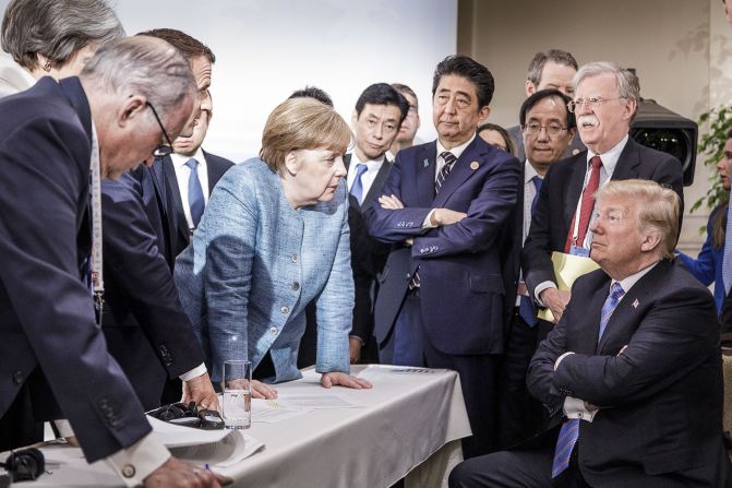 In this photo provided by the German Government Press Office, Merkel talks with Trump as they are surrounded by other leaders at the G7 summit in June 2018. According to two senior diplomatic sources, <a href="https://www.cnn.com/2018/06/11/politics/g7-photo/index.html" target="_blank">the photo was taken</a> when there was a difficult conversation taking place regarding the G7's communique and several issues the United States had leading up to it.