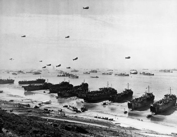 Landing craft and a fleet of protection vessels approach Omaha Beach.