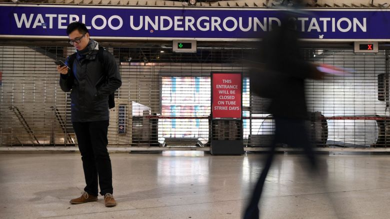 A man looks at his mobile phone at a barriered entrance to a tube station in Waterloo station in central London on January 9, 2017 during a 24-hour tube strike. 
A strike on the London Underground caused major disruption on January 9, as almost all stations in the city centre shut and services were cancelled in a dispute over jobs and ticket office closures. Millions of passengers were forced to take overcrowded buses or overland trains, or work from home, after the 24-hour walk-out by the RMT union.
 / AFP / BEN STANSALL        (Photo credit should read BEN STANSALL/AFP/Getty Images)