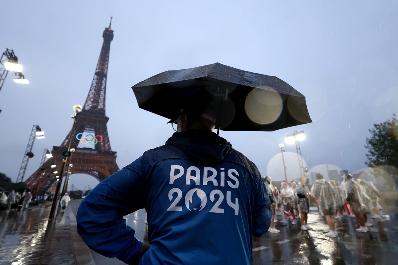 Staff shelter from the rain during the opening ceremony of the Olympic Games Paris 2024 on July 26.