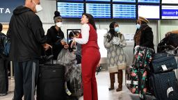 Passengers wearing masks speaks with a staff member at Paris-Charles-de-Gaulle airport on March 12, 2020 in Roissy en France, after US President announced a shock 30-day ban on travel from mainland Europe over the coronavirus pandemic that has sparked unprecedented lockdowns, widespread panic and another financial market meltdown. (Photo by Bertrand GUAY / AFP) (Photo by BERTRAND GUAY/AFP via Getty Images)