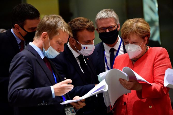 Merkel and other world leaders look over documents during a European Union summit in Brussels, Belgium, in July 2020. Leaders agreed to create a <a href="https://www.cnn.com/2020/07/21/economy/eu-stimulus-coronavirus/index.html" target="_blank">€750 billion ($858 billion) recovery fund</a> to rebuild EU economies ravaged by the coronavirus crisis.