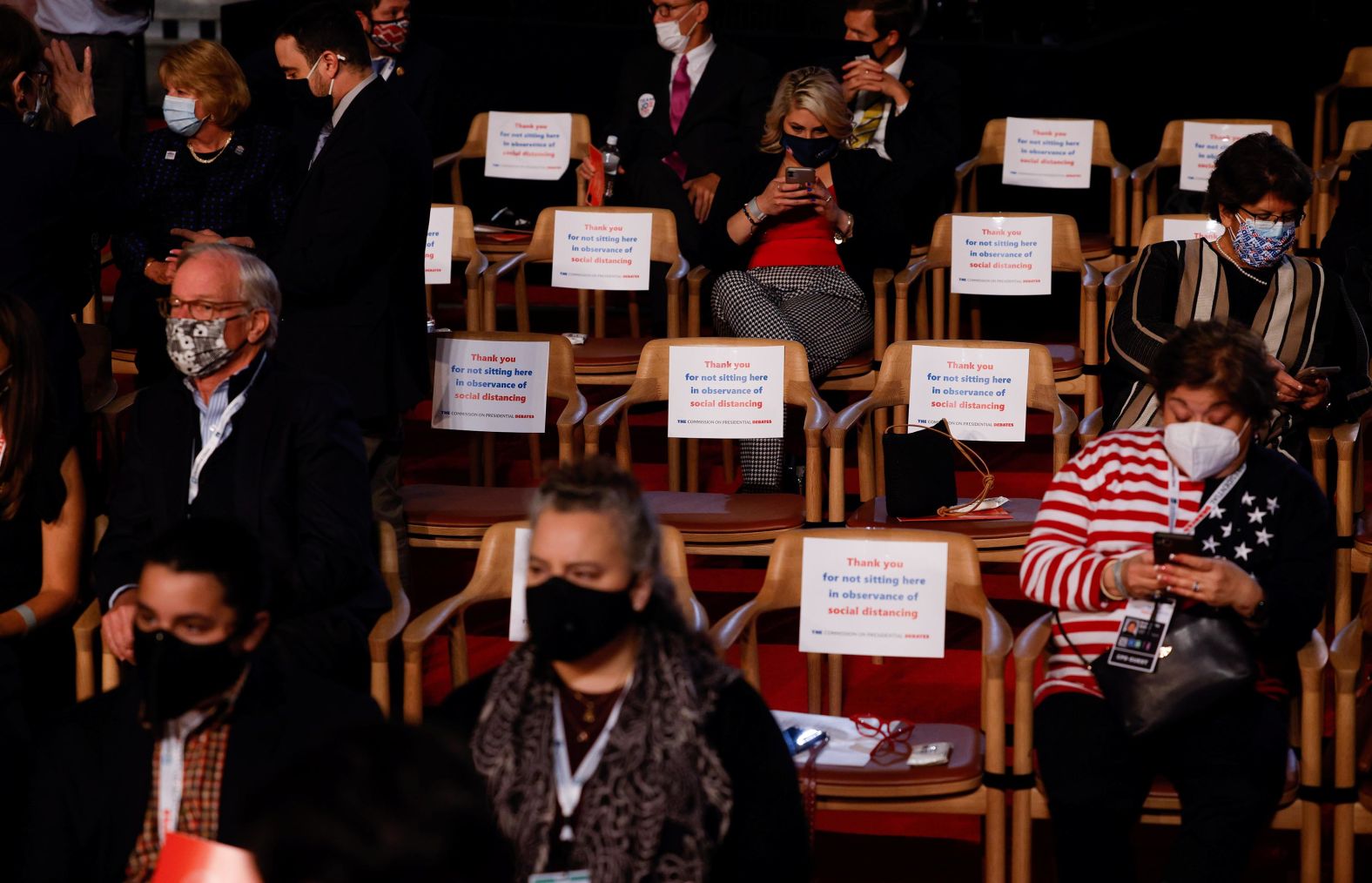 Audience members sit with chairs in between them to maintain social distancing.