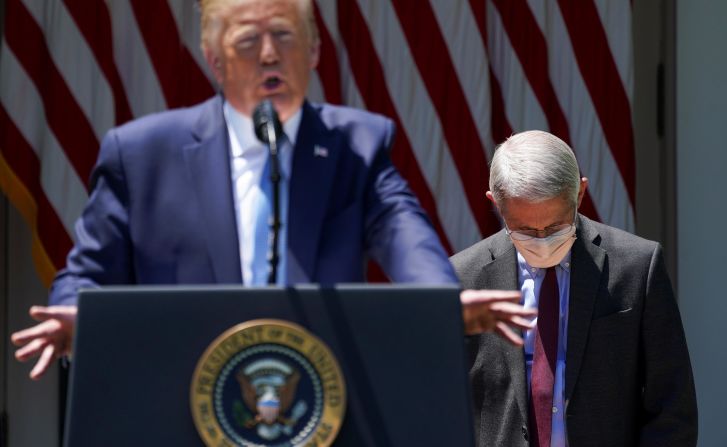 Dr. Anthony Fauci, director of the National Institute of Allergy and Infectious Diseases, looks down as Trump speaks in the White House Rose Garden in May 2020. Trump was unveiling <a href="https://www.cnn.com/2020/05/15/politics/trump-vaccine-effort-coronavirus/index.html" target="_blank">Operation Warp Speed,</a> a program aimed at developing a coronavirus vaccine by the end of the year.