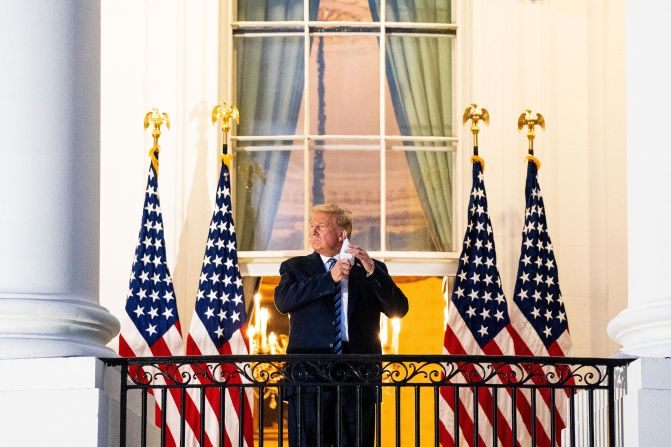 Despite his doctors saying he was "not out of the woods yet," Trump removes his mask for a photo-op upon returning to the White House.