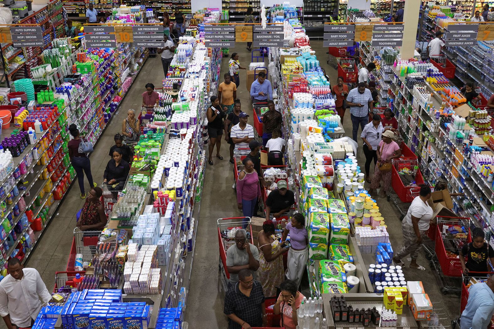 People in Kingston, Jamaica, wait in line with groceries Monday as Beryl approaches.