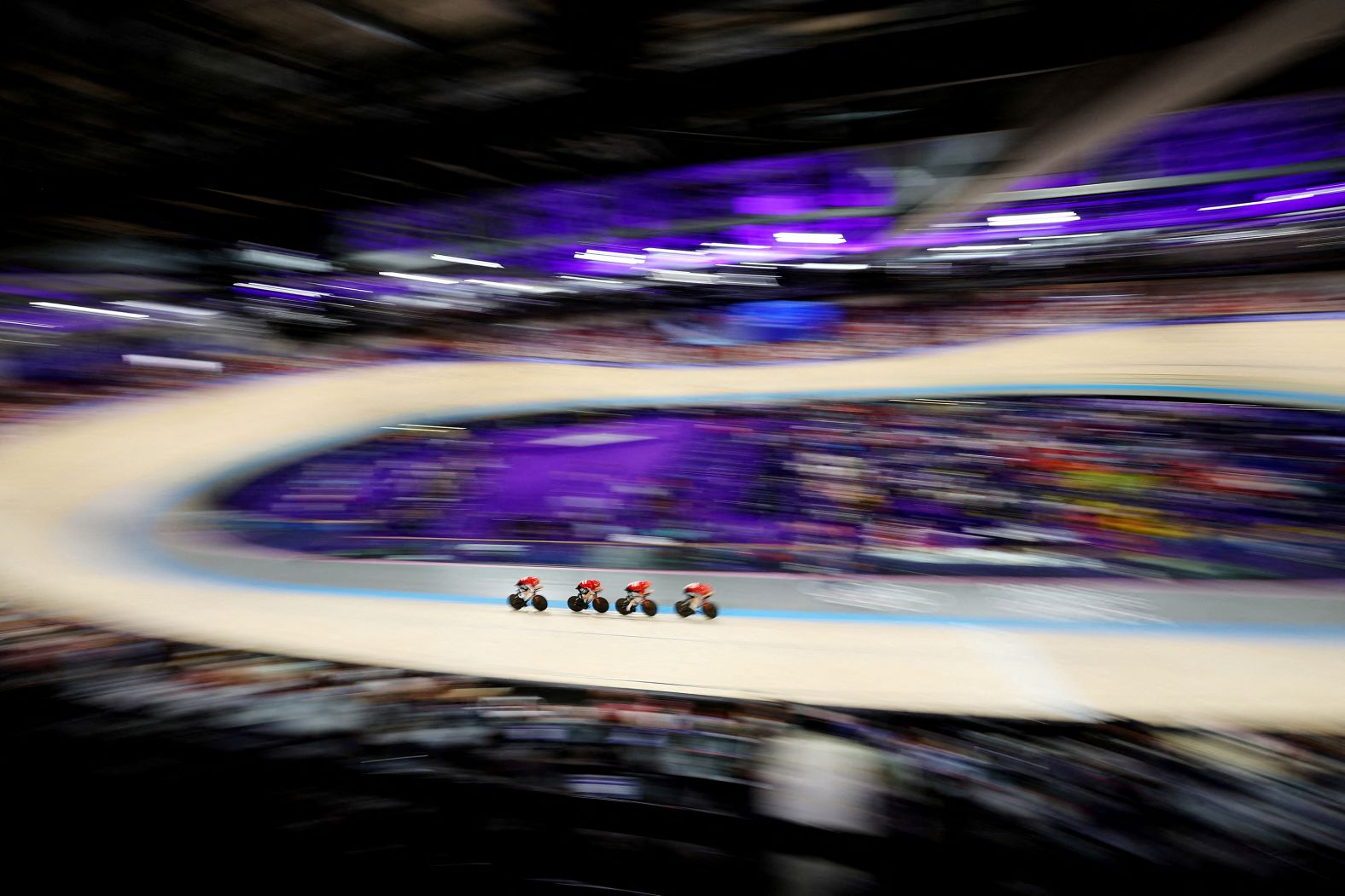 Track cyclists compete in a team pursuit qualifier on August 5.