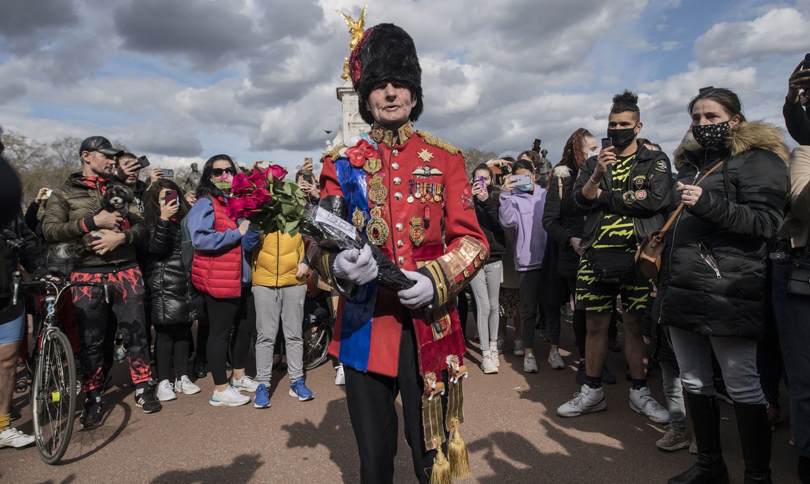 A man arrives to lay flowers outside London's Buckingham Palace on Friday, April 9.