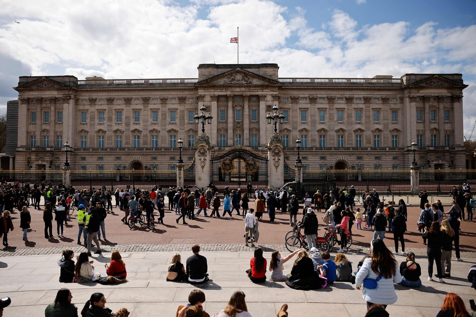 People gather outside Buckingham Palace, where the flag was flying at half-staff.