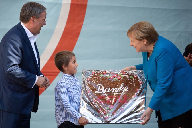A child gives Merkel a gingerbread heart with the inscription "Danke CDU," meaning "Thank you, CDU," during a Christian Democratic Union campaign event in Aachen, Germany, in September 2021. At left is Armin Laschet, Merkel's successor at the helm of the CDU, a long-time ally of the Chancellor and the party's deputy leader since 2012. He was <a href="https://www.cnn.com/2021/09/22/europe/germany-election-explainer-cmd-intl/index.html" target="_blank">one of the candidates who ran to replace her.</a>