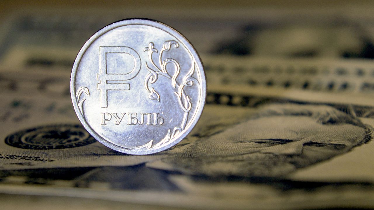 A Russian ruble coin is pictured with US dollar bills in Moscow, on August 23, 2018. - Russia's ruble hit its lowest level against the dollar for more than two years, a day after the latest round of punitive US sanctions took effect. The ruble's value dropped to 69 against the dollar for the first time since April 2016, when the shocks from the first Western sanctions over Russia's actions in Ukraine were still being felt. (Photo by Alexander NEMENOV / AFP) (Photo by ALEXANDER NEMENOV/AFP via Getty Images)