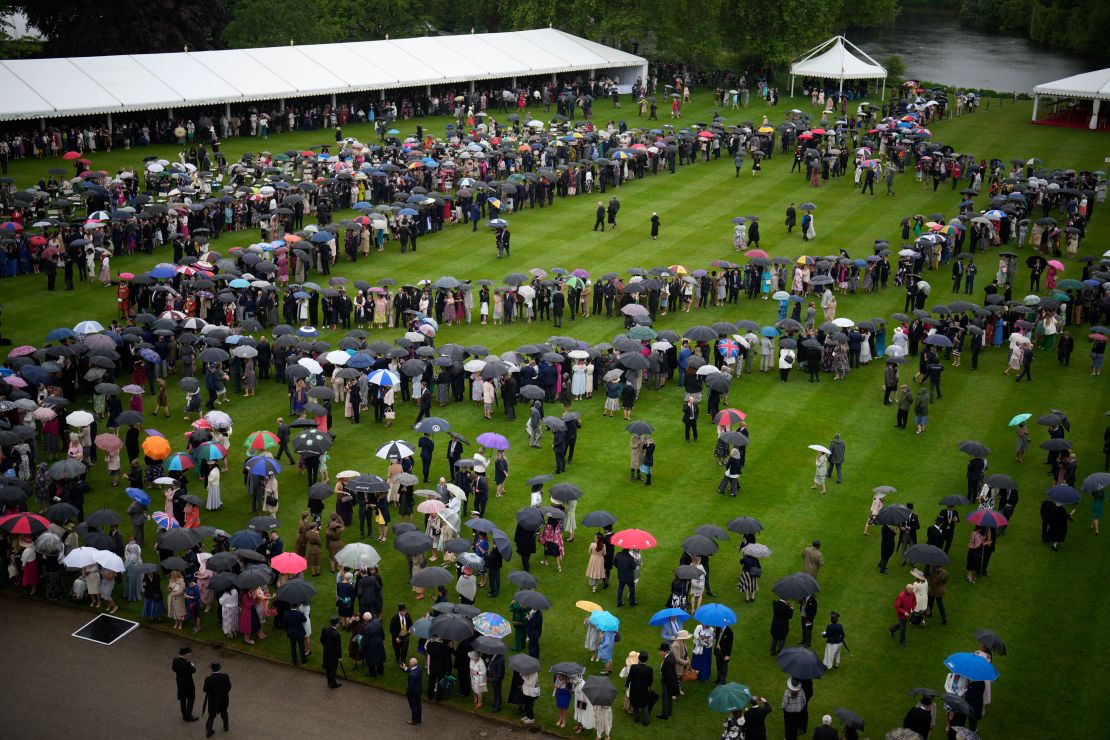 Guests brave the weather during a Royal Garden Party at Buckingham Palace on Wednesday.