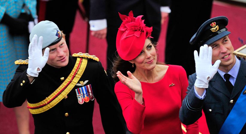 Catherine, Duchess of Cambridge, Prince William and Prince Harry wave as they pass the Houses of Parliament aboard the royal barge.