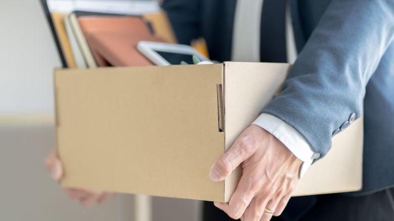 Stressful businessman packing a box for quit a job.