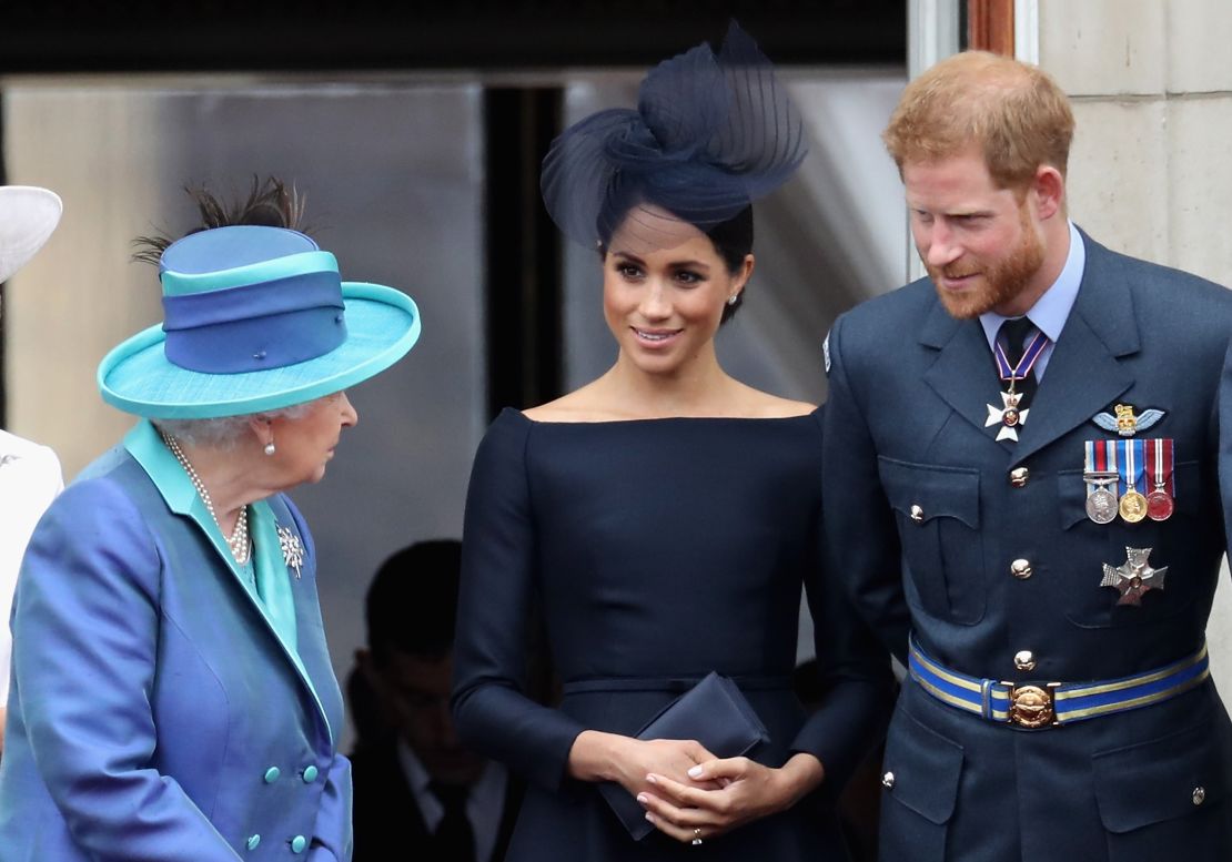 Queen Elizabeth II, Meghan, Duchess of Sussex, and Prince Harry watch a flypast on the balcony of Buckingham Palace as part of events to mark the centenary of the RAF on July 10, 2018 in London. 