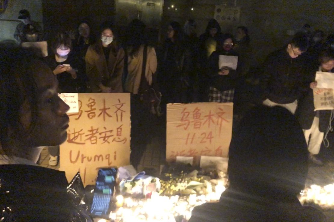 Demonstrators stand by protest signs in Shanghai, China, on Saturday, Nov. 26, 2022. 