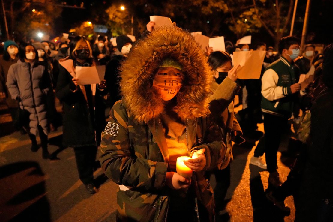 A Beijing protester holds a candal in demonstrations on Sunday night.