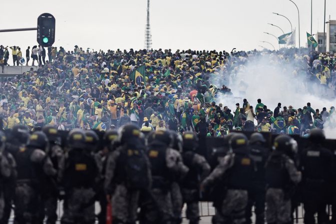 Security forces stand guard as supporters of former President Jair Bolsonaro demonstrate outside Planalto Palace in Brasilia.