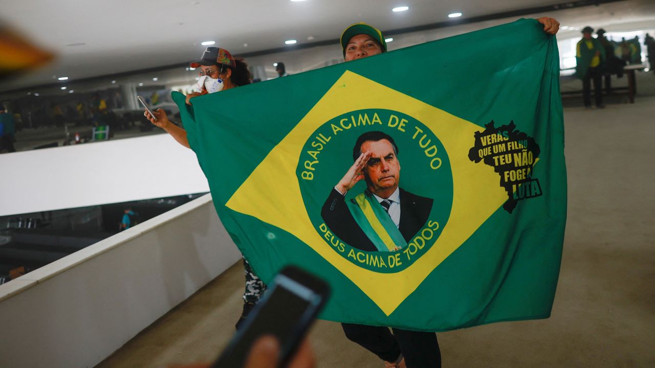 A supporter of Brazil's former President Jair Bolsonaro holds a flag depicting him during a demonstration against President Luiz Inacio Lula da Silva, in Brasilia, Brazil, January 8, 2023. REUTERS/Adriano Machado