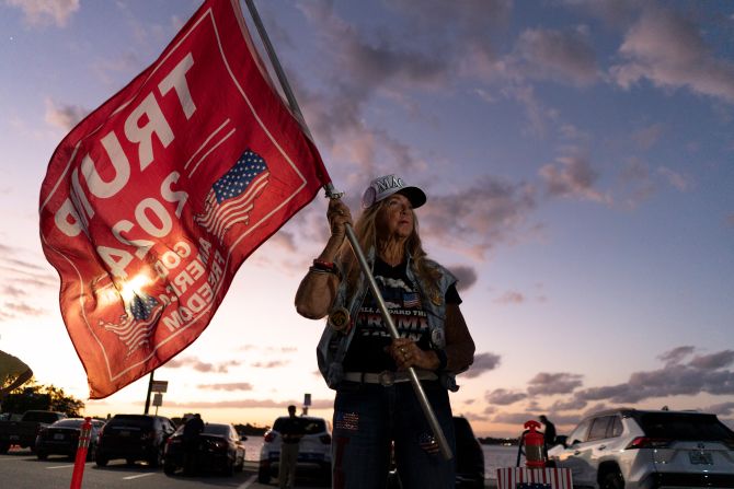 Mary Kelley waves a Trump flag near the former president's Mar-a-Lago estate after he was indicted on March 30, 2023.